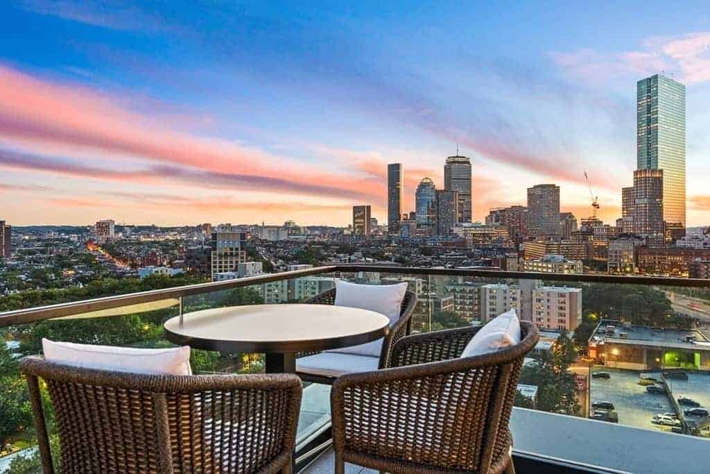 Private terrace with seating overlooking the Back Bay skyline at sunset