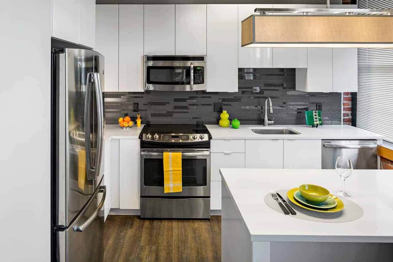 Kitchen with white cabinetry, quartz island and stainless appliances