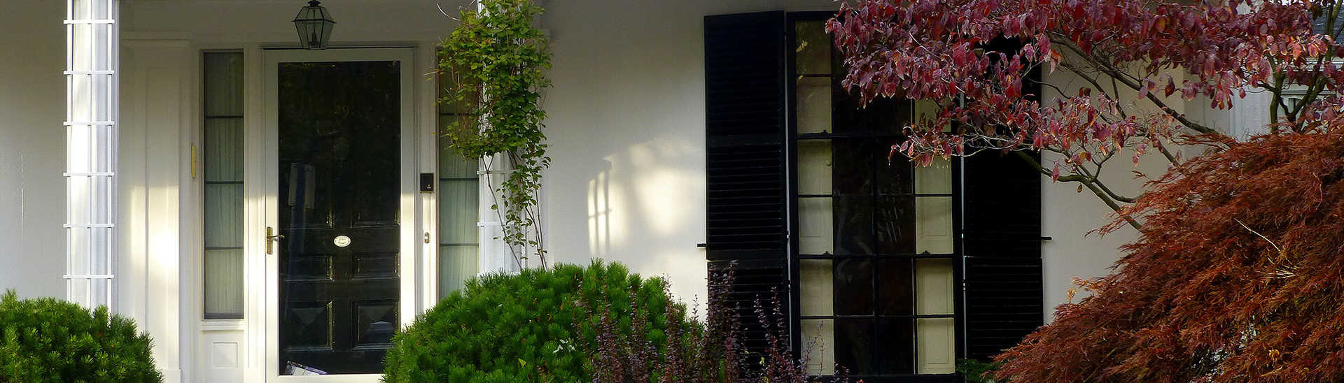 Close up of front of white house with black doors and black shutters