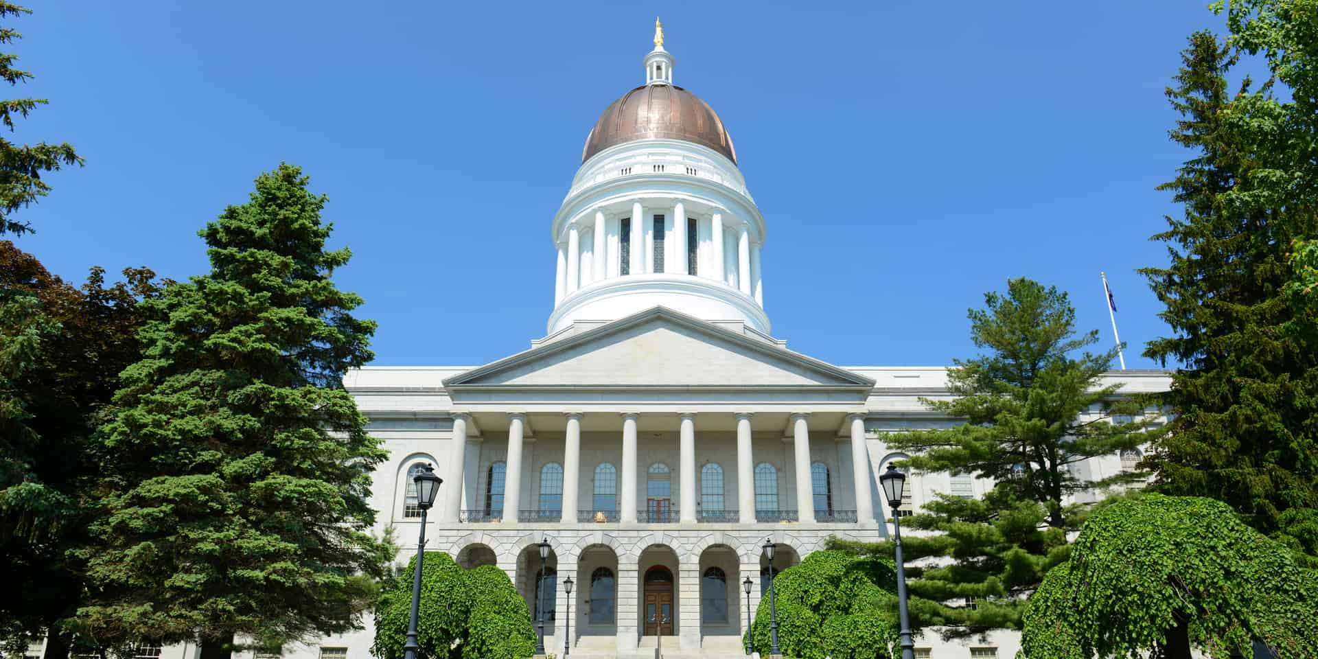 Upward angle shot of the front of the State House in Augusta, Maine