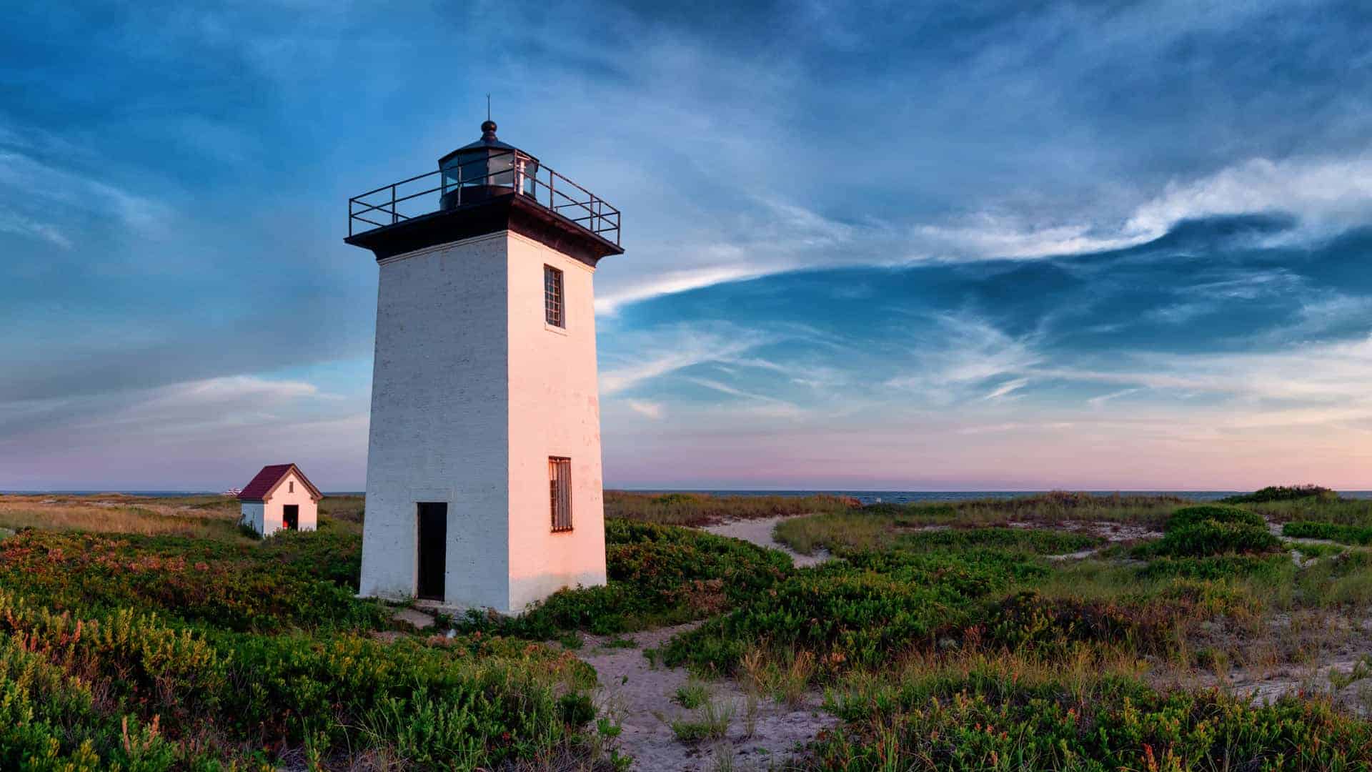Lighthouse on beach at dawn