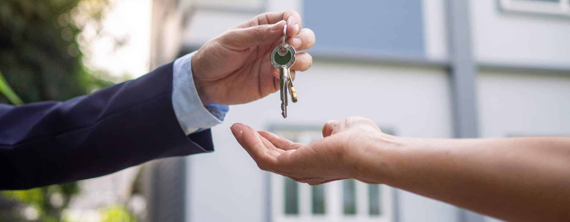 real estate agent handing over new house keys to client
