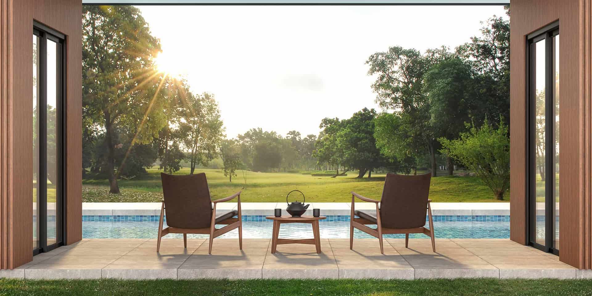 modern chairs outside modern house on patio looking over pool in backyard