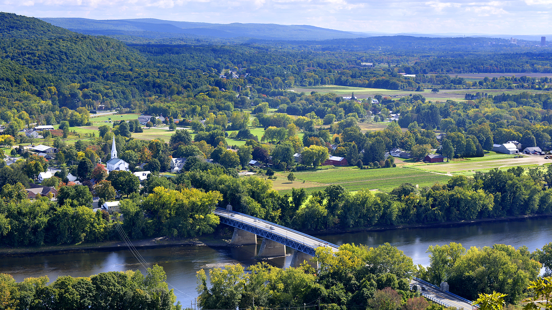 arial view of rolling green hills with suburban neighborhoods