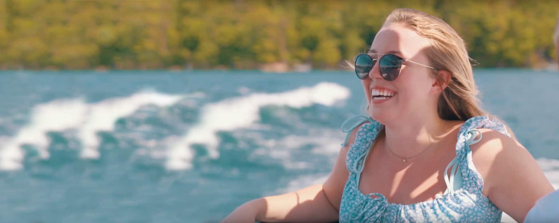 woman with sunglasses on a boat with water in the background