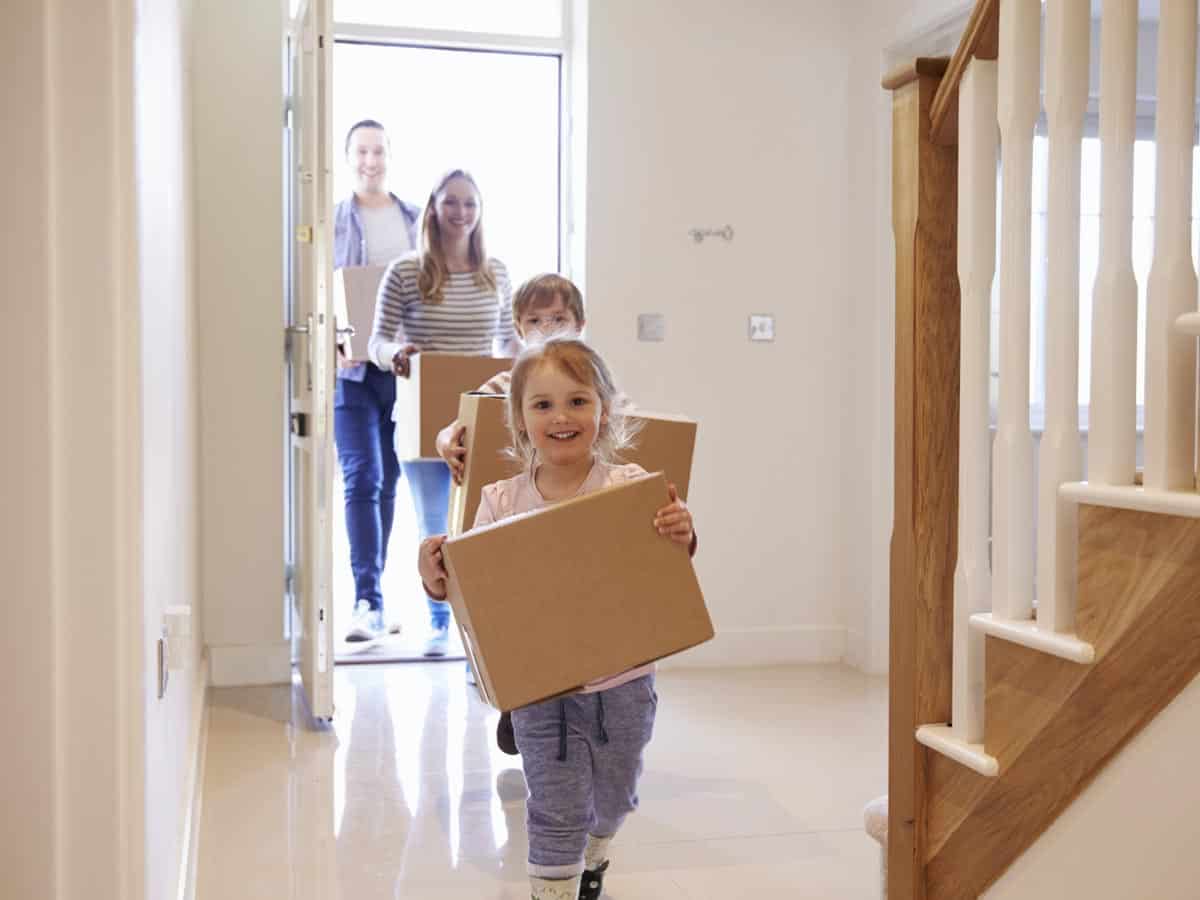 children running down hallway with moving boxes